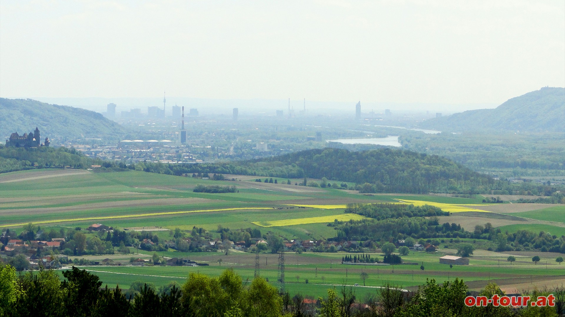 Im Sdosten, zwischen Bisamberg und Leopoldsberg, zeigt sich die Skyline von Wien. Im Vordergrund noch die Burg Kreuzenstein und Korneuburg.