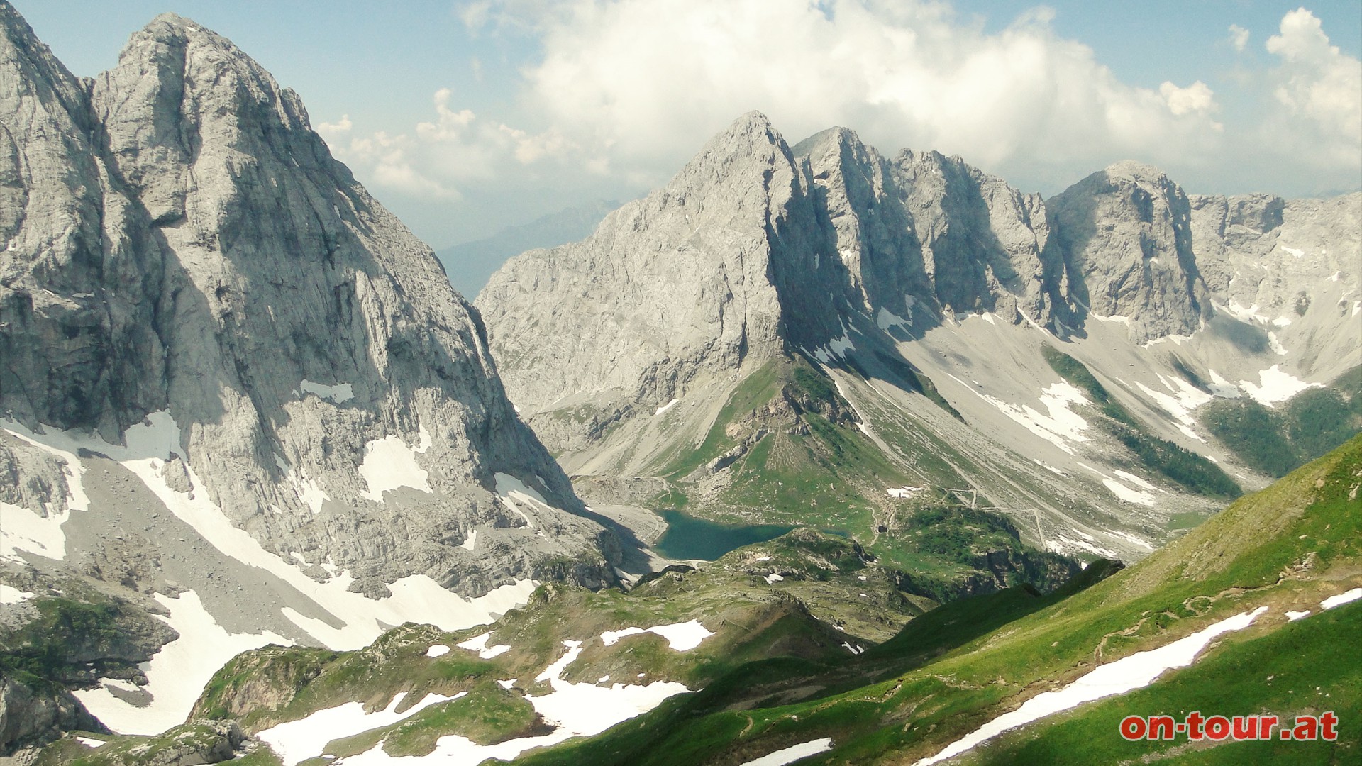 Im Osten reicht der Blick hinunter zum Wolayersee, dem Wolayerpass und zur Wolayerseehtte. Dahinter erheben sich der Seekopf und das Biegengebirge.